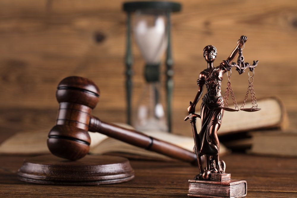 Lawyer Statue and Gavel on Wooden Table